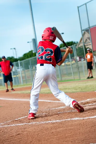 Giovane giocatore di baseball oscillando il pipistrello — Foto Stock