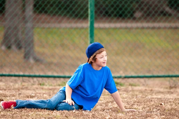 Mignon garçon assis sur herbe — Photo