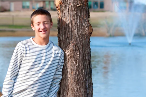 Beau adolescent appuyé sur l'arbre — Photo