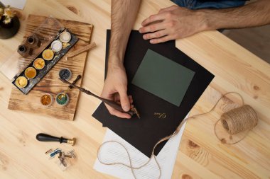 İnsan elleri mürekkeple modern el yazısı yazıyor.