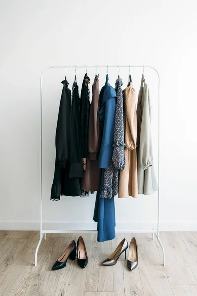 Capsule of casual clothes on a rack over white background