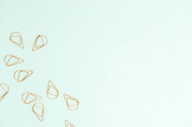 Açık mavi arkaplanda birkaç bakır renkli ofis atacı