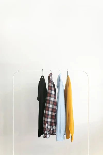 Rack com roupas de cápsula sobre fundo branco Conceito de minimalismo — Fotografia de Stock