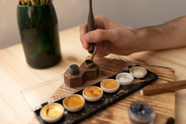 Kaligraf elini siyah mürekkebe batırdı. Yaratılış konsepti.