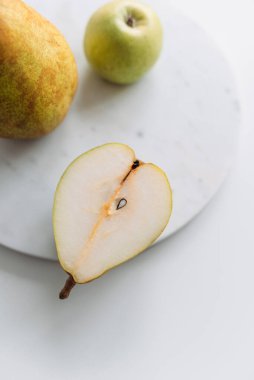 Armut ve beyaz masada mermer tahtalı bir elma. Kapat.