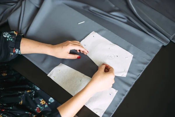 Dressmaker rysunek wzoru do cięcia ubrania z szarej tkaniny — Zdjęcie stockowe