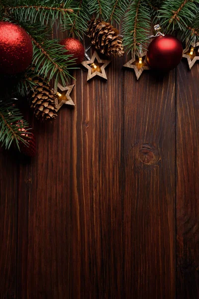 モミの枝 コーン 赤い泡と暗い木製のボード上の星の形のライトを持つクリスマスの背景 最上階だ コピースペース クリスマスの装飾 — ストック写真
