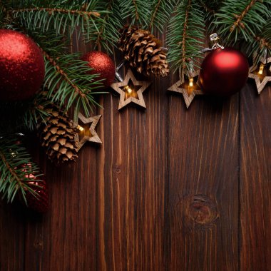 Noel arka planında köknar dalları, koniler, kırmızı mücevherler ve tahta üzerinde yıldız şeklinde ışıklar var. Üst Manzara. Uzayı kopyala Xmas dekorasyonu