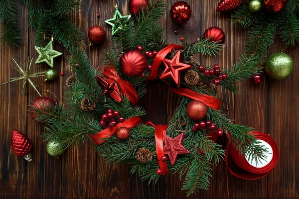 Çiçekçi eller tahta kahverengi arka planda Noel çelengi yapıyor. Üst Manzara. Yeni yıl ya da Noel kutlaması konsepti