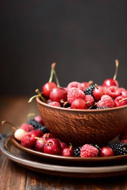 Renkli böğürtlenleri yakından çek. Çeşitli ahududu, böğürtlen, Bektaşi üzümü ve tatlı kiraz karışımı. Seçici odak