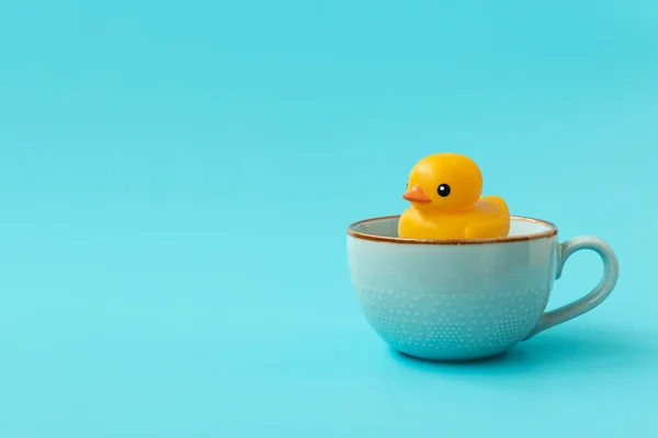 Желтая Резиновая Утка Плавающая Чашку Чая Синем Фоне Творческая Концепция — стоковое фото