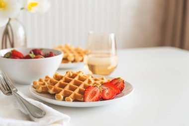 Beyaz tabakta çilekli Belçika waffleları. Kahvaltı konsepti. Boşluğu kopyala