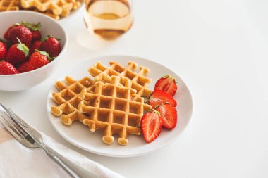 Beyaz tabakta çilekli Belçika waffleları. Kahvaltı konsepti. Uzayı kopyala Üst görünüm