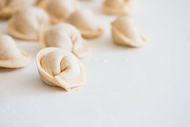 Beyaz masada pişmemiş ev yapımı pelmeni. Pelmeni, ravioli veya etli hamur tatlısı yapma süreci