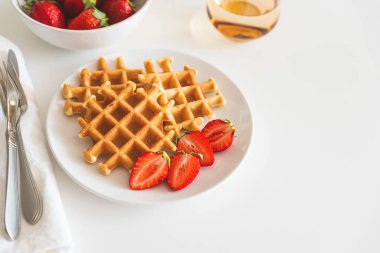 Beyaz tabakta çilekli Belçika waffleları. Kahvaltı konsepti. Uzayı kopyala Üst görünüm