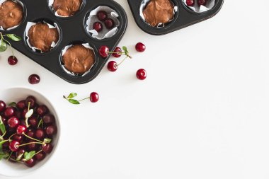 Beyaz ahşap masada taze böğürtlenli ev yapımı kirazlı kek pişirmek. Üst görünüm