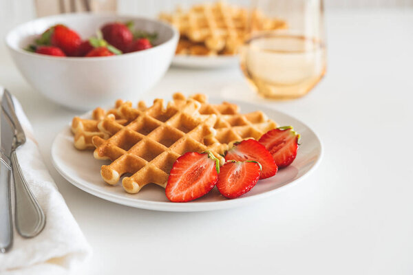 Belgian waffles with strawberry on white plate. Breakfast food concept. Copy space