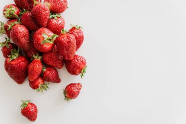Pile of fresh strawberries on white wooden table. Top view