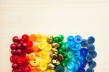 Kopya alanı olan çok renkli düğmeler. Ahşap arkaplanda renkli gökkuşağı düğmeleri