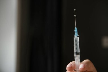 Elinde aşı olan bir şırınga.