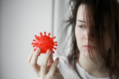 Elinde kırmızı virüs olan hasta bir genç kadın. Coronavirüs sembollü hasta bir kadın.