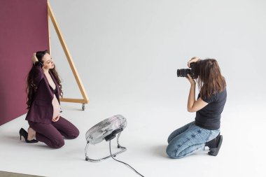 Stüdyodaki fotoğraf çekiminde hamile bir kadın, fotosoplama işlemi. Model ile fotoğrafçı