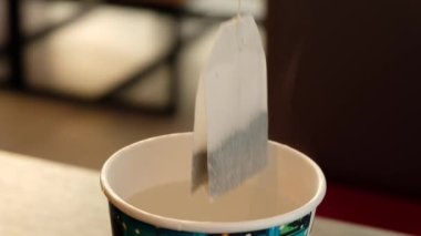 Kağıt bardakta suda çay poşeti