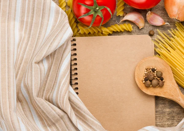 Cucchiaio di legno, taccuino e ingredienti — Foto Stock