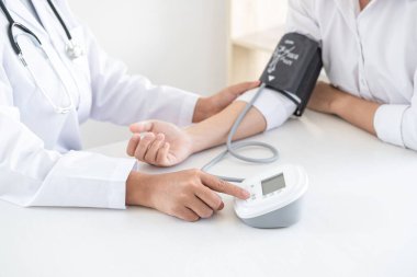 Doktor kan basıncını ölçerek hastayı muayene ederek, sonuçları sunarak ve tedavi yöntemi, sağlık ve tıbbi konsept önererek ölçüyor..