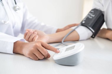 Doktor kan basıncını ölçerek hastayı muayene ederek, sonuçları sunarak ve tedavi yöntemi, sağlık ve tıbbi konsept önererek ölçüyor..