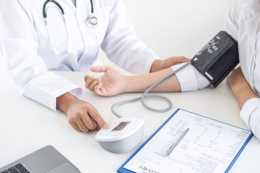 Doktor kan basıncını ölçerek hastayı muayene ederek, sonuçları sunarak ve tedavi yöntemi, sağlık ve tıbbi konsept önererek ölçüyor..
