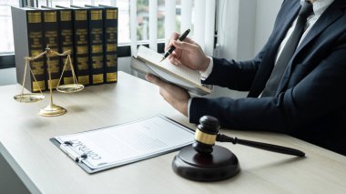 Avukat ya da noter önemli bir dava ve ahşap tokmak ile ilgili belgeler üzerinde çalışıyor. Mahkeme salonundaki pirinç tartı..