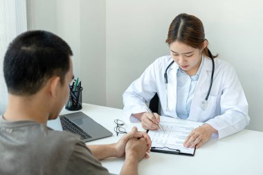 Doktor, teşhis, reçete yazma ve klinikte çalışırken hastaya tavsiye verme süresince hastaların hastalık ve semptomlarını açıklamaya çalışıyor.