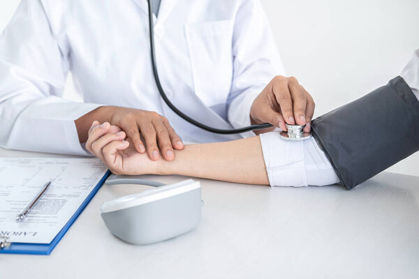 Doctor using a measuring blood pressure checking patient with examining, presenting results symptom and recommend treatment method, Healthcare and medical concept.