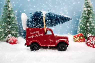 Çatıda yeşil köknar ağaçlı Noel kamyonu. Kış mevsiminde szenary ile. Noel 'de eve dönüş mesajım var.