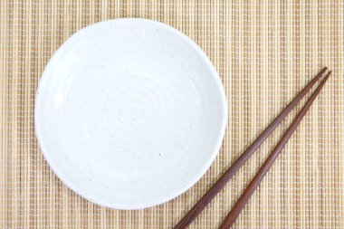 Boş beyaz tabak yemek çubukları ile