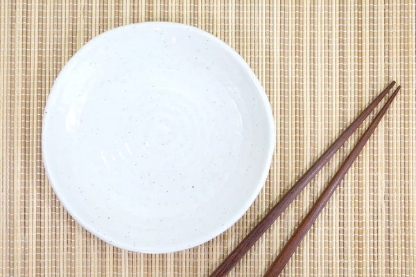 Leerer weißer Teller mit Essstäbchen — Stockfoto
