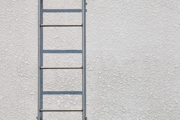 Escada de metal contra parede cinza — Fotografia de Stock
