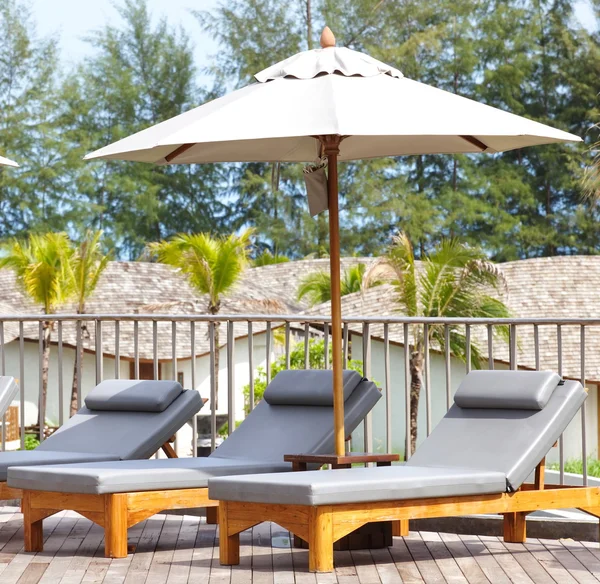 Sonnenschirm und Liegestuhl im — Stockfoto