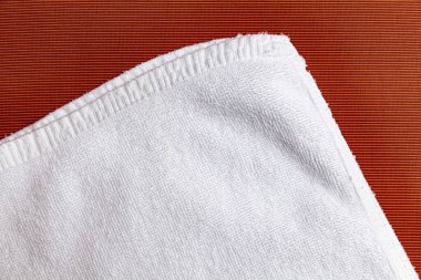 Kahverengi ahşap masaya katlanmış temiz beyaz havlular.