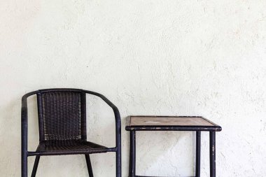 Evin balkonunda boş siyah plastik rattan sandalye.