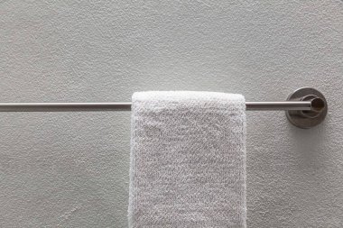 Temiz beyaz havlular banyodaki paslanmaz çelik korkuluklara tutunur.