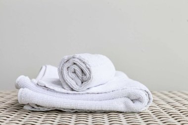 Beyaz ahşap bir masada katlanmış temiz beyaz havlular..