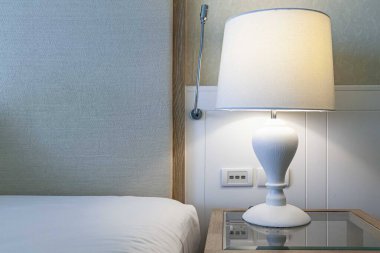 Seramik masa lambası evdeki yatak odasında beyaz.