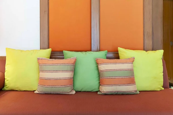 現代の家庭のリビングルームで茶色の生地の長いソファの上に緑と茶色のクッション — ストック写真