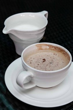 Kahve fincanı siyah ahşap masaya yerleştirilmiş.