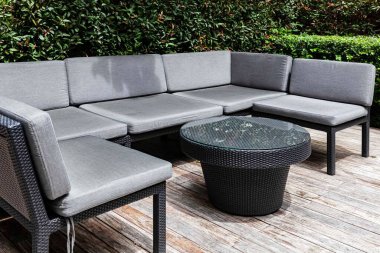 Siyah ahşap sandalyeler ve gri yastıklar oturma odasında.