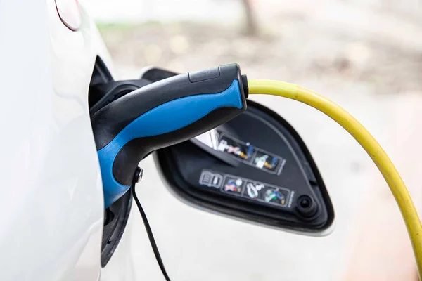 電気自動車用駐車場の充電器に接続されている車 ロイヤリティフリーのストック画像