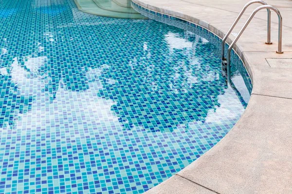 Wide swimming pool and green artificial turf inside the villa