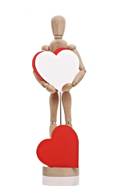 Boneca de madeira detém papel em forma de coração — Fotografia de Stock